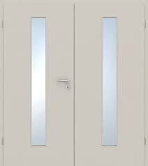 A pair of off-white double interior doors with tall, narrow vertical frosted glass panels in each door and a small central lockset.