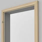 A light natural wood rectangular mirror frame shown against a plain light gray wall.