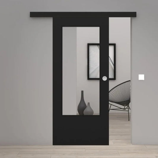 A modern black sliding door with a large vertical glass panel, shown partially open in a minimalist interior setting with light gray walls and light wood flooring.