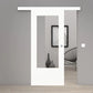 A modern white sliding glass door with a white header and bottom frame, shown in an open position revealing a minimalist gray interior with a black wire chair and framed wall art.