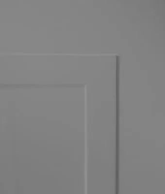 A close-up of a light gray paneled surface, showing a recessed rectangular panel corner.
