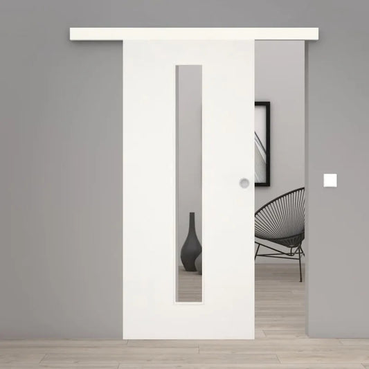 A modern white sliding door with a vertical rectangular glass panel, shown installed in a minimalist gray interior doorway with light wood flooring and a black wire chair visible in the background.