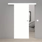 A modern white sliding door with a minimalist metal doorknob, shown partially open in a minimalist gray room with light wood flooring.