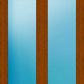 A double door or window frame in medium brown wood with two tall vertical frosted glass panels showing a blue gradient background.