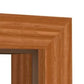 Close-up of a wood-framed doorway corner showing the warm medium-brown grain and layered molding profile against a white background.